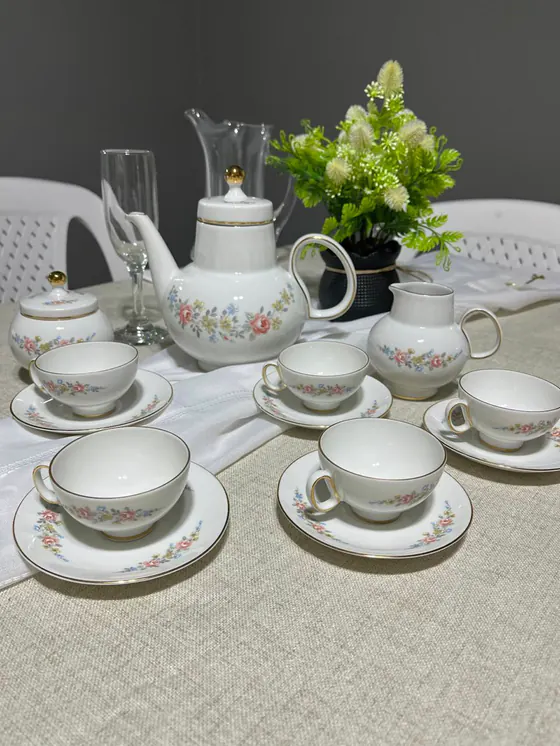 Juego de té de porcelana con flores rosas, celestes y amarillas y borde dorado